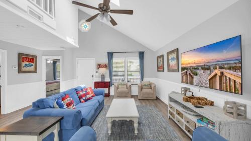 un soggiorno con divano blu e ventilatore a soffitto di Captain's Cove - Pool Rooftop and Inlet Views a Myrtle Beach