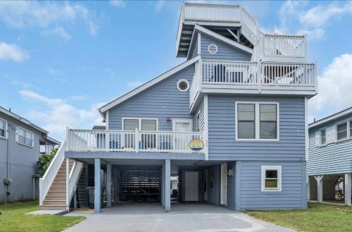 a blue house with a balcony on top of it at Captain's Cove - Pool Rooftop and Inlet Views in Myrtle Beach