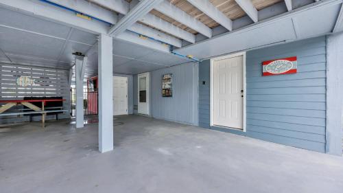 a garage with a blue wall and a white door at Captain's Cove - Pool Rooftop and Inlet Views in Myrtle Beach