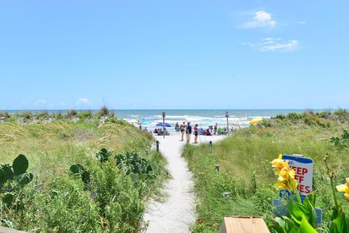 a path leading to a beach with people on it at Captain's Cove - Pool Rooftop and Inlet Views in Myrtle Beach