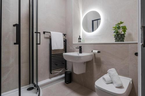 a bathroom with a sink and a toilet and a mirror at Sunnie stays apartment harrington chambers in Liverpool