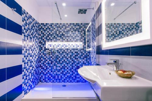 a blue and white bathroom with a sink and a shower at Il Golfo Suites in Sorrento