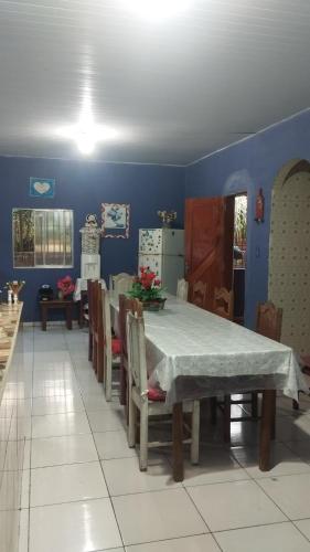 una sala da pranzo con tavolo e sedie e una cucina di Família Marcon a Belém