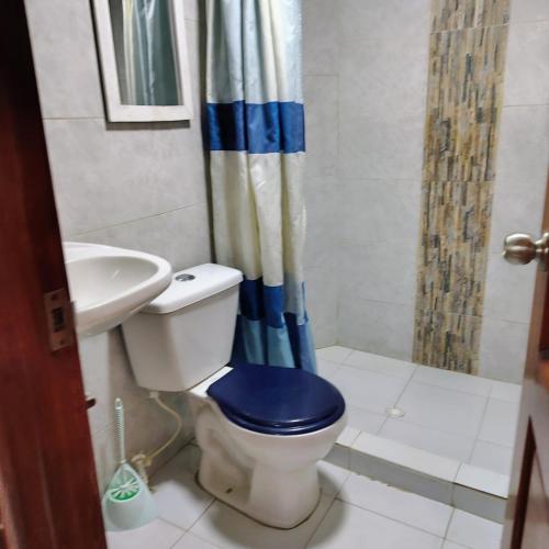 a bathroom with a toilet with a blue seat and a sink at La chonta in Capurganá