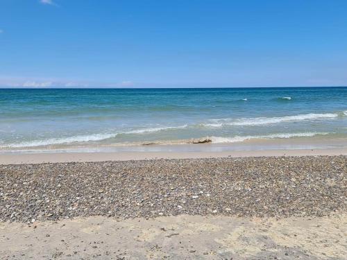 a sandy beach with the ocean in the background at 4 person holiday home in Fjerritslev-By Traum in Fjerritslev