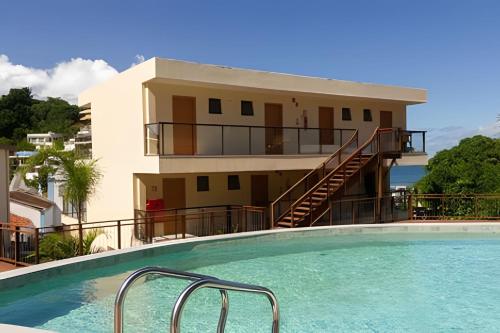 a house with a swimming pool in front of a building at MAR DÁ LIBERDADE com Amerigo Vespucci in Morro de São Paulo