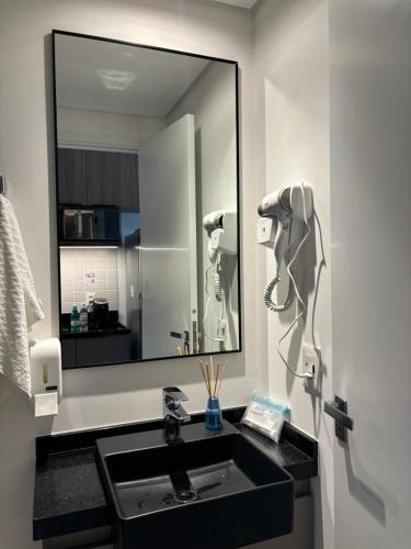 un bagno con un lavandino e un grande specchio di Studio almagah a San Paolo