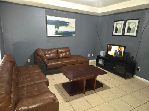 a living room with a couch and a table and a tv at fancy wonderful home! in Houston