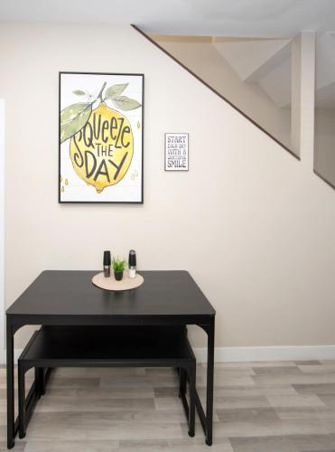 a black table in front of a white wall with a picture at Stylish Lemon 2BR and 3BA Townhouse in Tempe