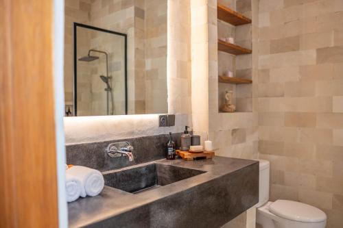 a bathroom with a sink and a toilet at Casa Goya Pererenan by REJA Villas in Badung