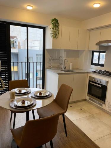 Una cocina con una mesa y sillas en una cocina. en Giannina Huarcaya Inmuebles, en San Antonio