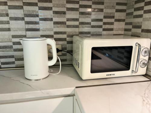 a microwave sitting on a counter next to a toaster oven at #1 Location Cozy Tbilisi Gateway in Tbilisi City