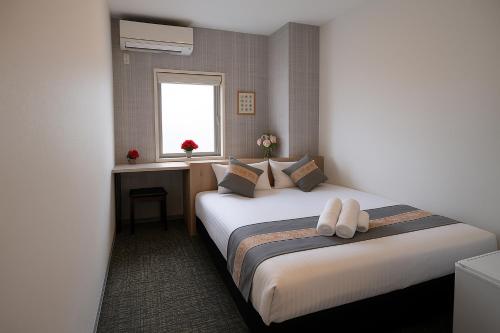a hotel room with two beds and a window at Plaza In Kanku Hotel in Izumi-Sano