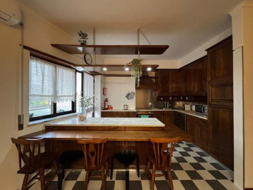 a kitchen with a wooden table and some chairs at Pequeno Refúgio in Braga