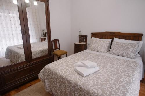 a bedroom with a bed with a mirror and a bed sidx sidx sidx at Pequeno Refúgio in Braga