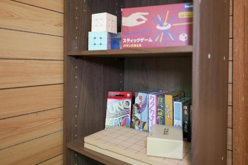 a book shelf with books and a box on it at アウトドアアドベンチャー北軽井沢 in Wada