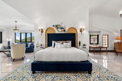 a bedroom with a blue bed and a living room at Casa Blue Laguna I Tropical Scape with Ocean View in Las Croabas