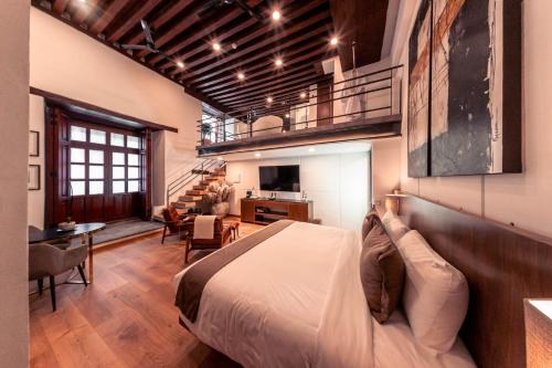 a bedroom with a bed and a living room at Domingo Santo Hotel Boutique in Mexico City