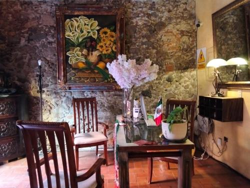 a dining room with a table with chairs and flowers on it at Hotel Antigua Casa de Piedra in San Miguel de Allende