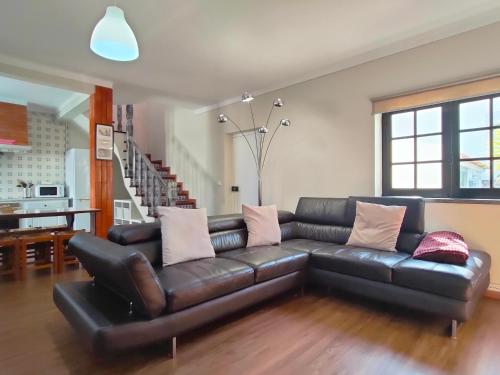 a black leather couch in a living room at Baleal Classic Waves Guest House in Baleal