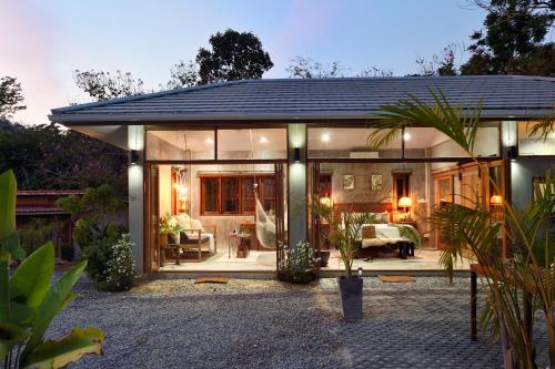 a large glass house with a living room at Boutique Jungle Villa - Baan ChaOm in Ko Lanta