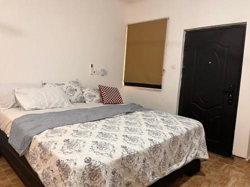 アクラにあるEspada Lodgeのベッドルーム1室(ベッド1台、黒いドア付)
