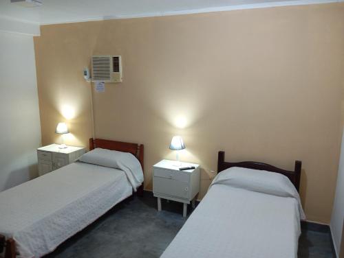 a room with two beds and two night stands with lamps at Departamento federación in Federación