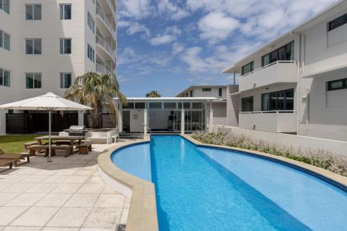 una piscina frente a un edificio en Panorama Penthouse Luxe Ocean Views & Pool, en Mount Maunganui