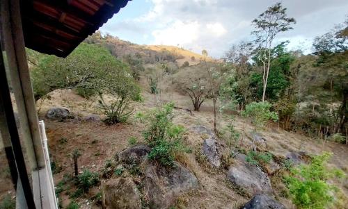 a view of a mountain with trees and rocks at Chácara 2 coqueiros in Paraisópolis