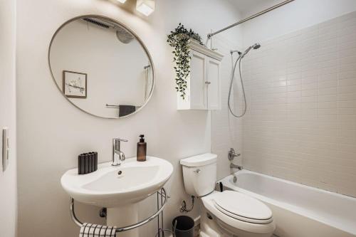 a bathroom with a sink and a toilet and a mirror at SoCo Haven - Stylish Stay - Sleeps 8 & Wifi in Austin