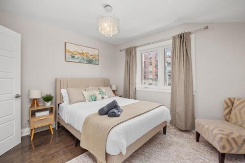 a bedroom with a bed and a chair and a window at Entire Unit - Steps From History - 5 Mins To Beaches in Toronto