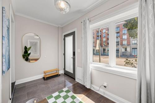an empty hallway with a window and a table at Entire Unit - Steps From History - 5 Mins To Beaches in Toronto