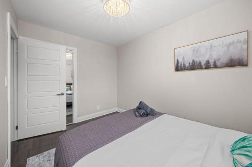 a bedroom with a bed and a picture on the wall at Entire Unit - Steps From History - 5 Mins To Beaches in Toronto