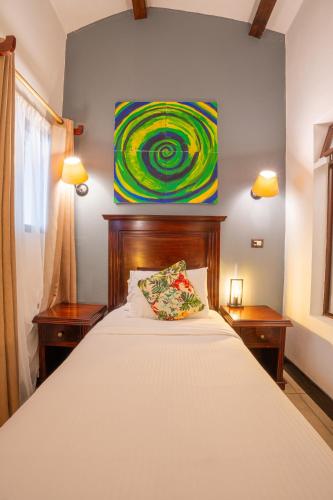 a bedroom with a bed with a painting on the wall at Camino Verde B&B Monteverde Costa Rica in Monteverde Costa Rica