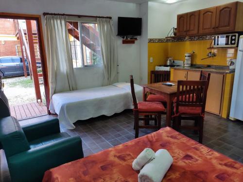 een kamer met een bed, een tafel en een keuken bij En Esta Tierra in Villa Gesell