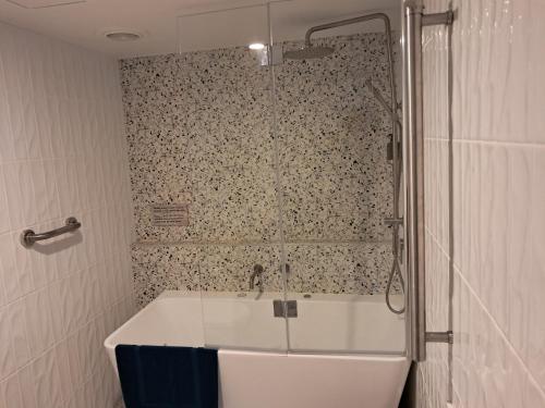 una bañera en un baño con ducha en Batehaven Resort, en Batehaven