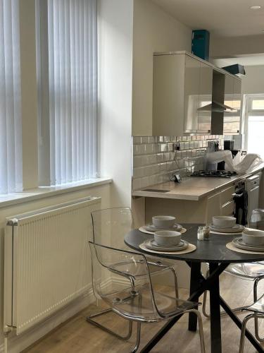 a kitchen with a table and chairs in a kitchen at Modern 2 Bedroom Flat - Central & Stylish in Newcastle upon Tyne