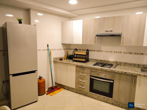 une cuisine avec un réfrigérateur et un plan de travail dans l'établissement Apartement de Luxe sur la plage de Achakar complexe avec piscine N2, à Tanger