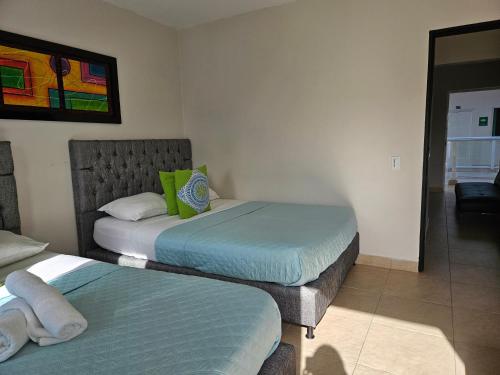 two twin beds in a room with at Caribbean Island Hotel Piso 2 in San Andrés