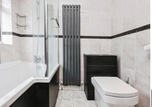 a white bathroom with a toilet and a shower at Entire luxury house Free Parking accommodations for contractors and long stays in Birmingham