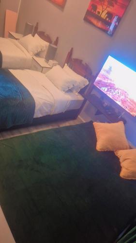 a bedroom with two beds and a computer monitor at Emerald Green Family Haven! in Rustenburg