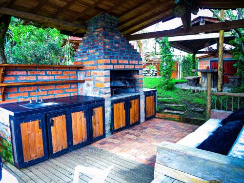a outdoor kitchen with a stone oven with a bench at Refugio Santa Elena in Santa Elena