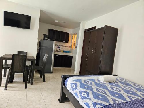 a bedroom with a bed and a table and a kitchen at Caribbean Island Hotel Piso 2 in San Andrés