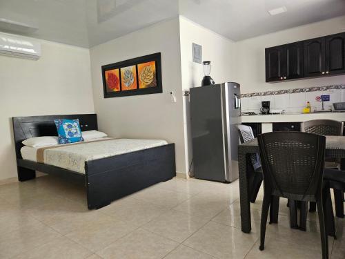 a bedroom with a bed and a table and a refrigerator at Caribbean Island Hotel Piso 2 in San Andrés