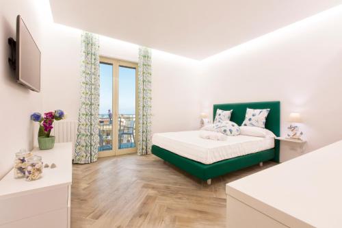 a bedroom with a bed and a large window at Il Golfo Suites in Sorrento