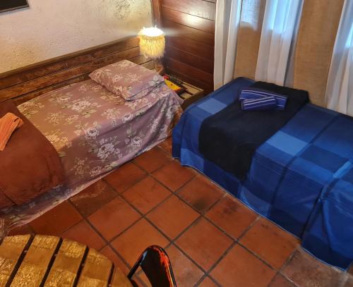 a small room with two beds and a table at Casa Limoeiro 5min da ilha in Alter do Chao