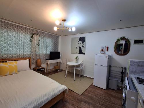 a bedroom with a bed and a desk and a kitchen at #A6 Open sale - 5mins to Hongdae Station in Seoul
