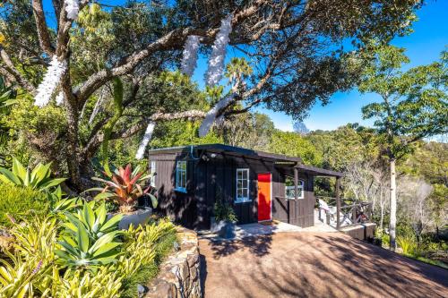 Palm BeachにあるJacksons Hideaway - Stay Waihekeの庭の赤い扉付き小屋
