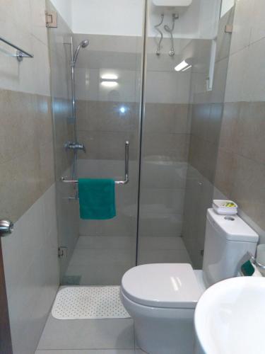 a bathroom with a shower with a toilet and a sink at Mystical Rose in Malabe