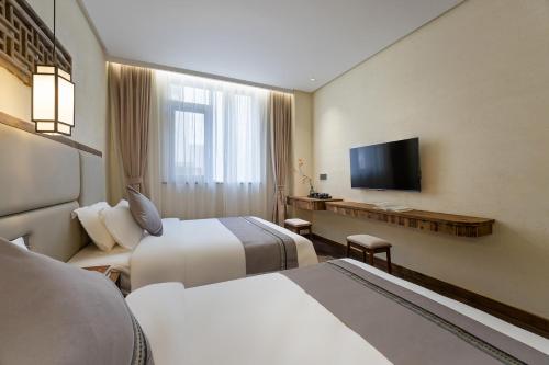 Floral Hotel Shexian Taibaiju B&B Huizhou Ancient City Branchにあるテレビまたはエンターテインメントセンター
